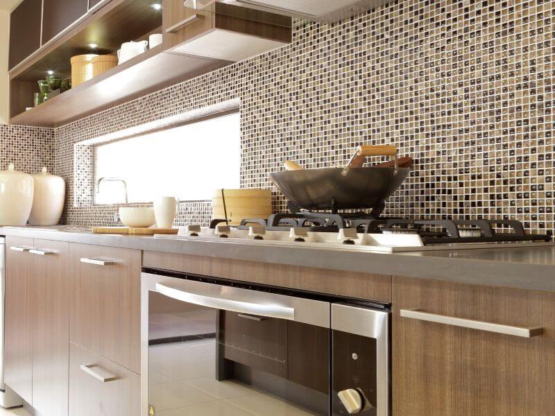 A modern kitchen renovation in Cairns featuring an oven, range hood and stove top.